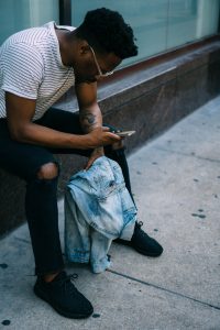 Man sitting with backpack and phone