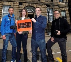 marketing team in Edinburgh holding sign which says #UncoverEdinburgh